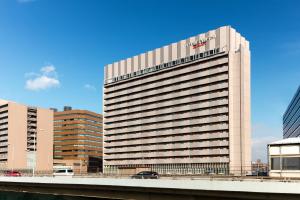 大阪市にあるコートヤード バイ マリオット 新大阪 ステーションの看板が上がる高層ビル