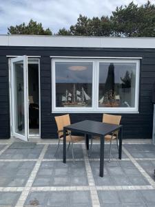a black table and chairs in front of a building at JJ Guesthouse Studio 37 in Skagen
