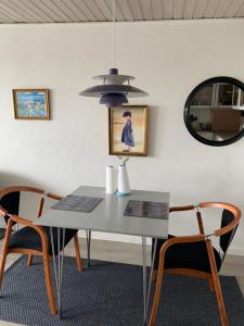 a dining room table with two chairs and a mirror at JJ Guesthouse Studio 37 in Skagen