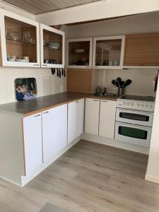 a kitchen with white cabinets and a stove top oven at JJ Guesthouse Studio 37 in Skagen