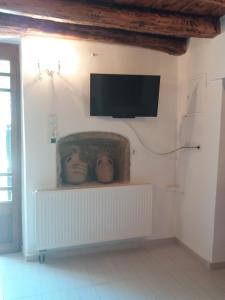 un soggiorno con TV a schermo piatto a parete di Heracles Traditional Cretan Houses a Spílion