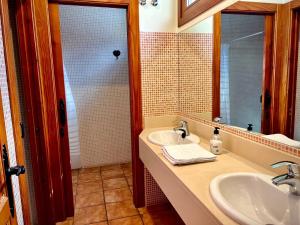 Baño con 2 lavabos y espejo en Apartamentos Turísticos Cuirgu, en Felechosa