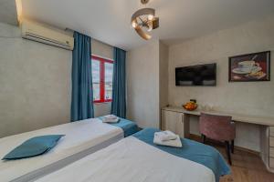 ベオグラードにあるHotel City Code Vizura garni RENEWのベッド2台とデスクが備わるホテルルームです。