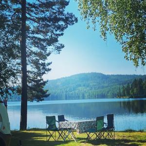 - un groupe de chaises assises à côté d'un lac dans l'établissement Snibben Höga Kusten, à Ramvik