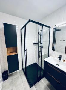 une salle de bain avec une douche en verre et un lavabo dans l'établissement AL-DOM Apartamenty Apartament 103, à Kołobrzeg 12 autres photos
