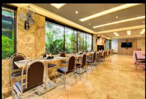 a dining room with tables and chairs in a building at Kohinoor Exotica in Lonavala