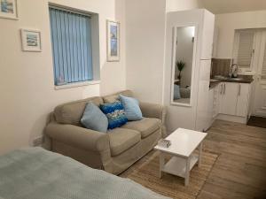 ein Wohnzimmer mit einem Sofa und einem Tisch in der Unterkunft The Haven 2 night minimum in Torpoint