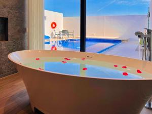 a bath tub in a room with a swimming pool at Jaw Resort & Spa in Jaww