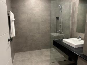 a bathroom with a sink and a glass shower at Raintree Boutique 