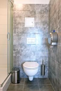 La salle de bains est pourvue d'une douche et de toilettes. dans l'établissement Dom Studencki Komenik, à Leszno