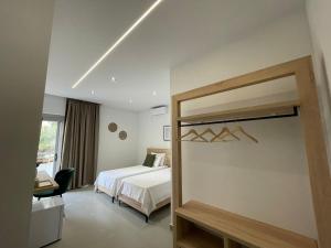 Habitación de hotel con cama y espejo en Helen's Seaside Resort, en Sarandë