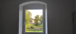 an arched window with a view of a yard at Autrefois la Cure in Bonnefontaine