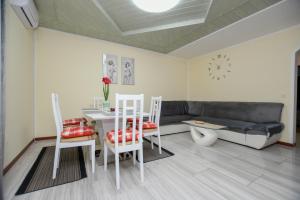 een woonkamer met een bank en een tafel en stoelen bij Apartments Katja in Poreč
