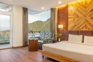 穆索里Country Inn Premier Pacific Mall Road Mussoorie的一间卧室，里面有一张床、一把椅子和一扇窗户