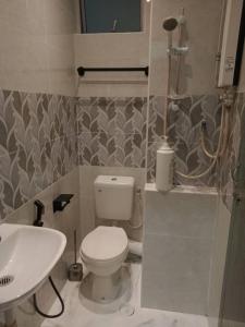 a bathroom with a white toilet and a sink at Muslim Homestay blue Adik Aisyah Apartment in Tanah Rata