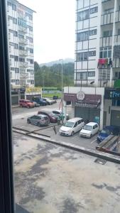a view from a window of a parking lot with cars at Muslim Homestay blue Adik Aisyah Apartment in Tanah Rata