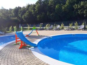 a slide next to a swimming pool at Apartamenty Przy Morzu Dominikana in Sianozety