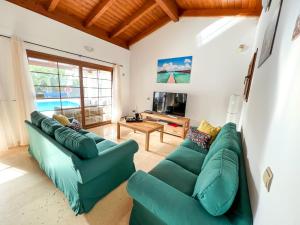 sala de estar con sofá verde y mesa en Las Velas en Corralejo