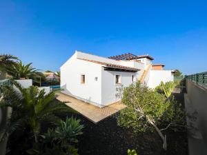 - une vue sur une maison blanche avec des arbres dans l'établissement Las Velas, à Corralejo
