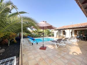- une piscine avec toboggan et parasol à côté d'une maison dans l'établissement Las Velas, à Corralejo