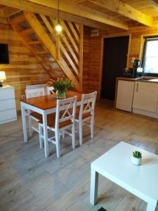 uma sala de jantar com uma mesa e cadeiras brancas em Domki Arkadia Mielno em Mielno