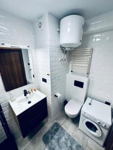 une salle de bains blanche avec toilettes et lavabo dans l'établissement AL-DOM Apartamenty Apartament 103, à Kołobrzeg