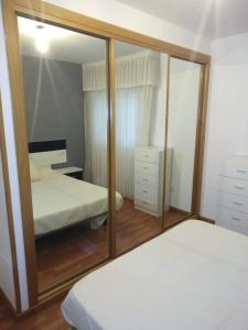 a bedroom with two beds and a mirror at MARINA SOL VIVEIRO in Viveiro