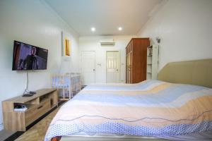 1 dormitorio con 1 cama grande y TV de pantalla plana en Laguna Villa 2 en Hua Hin