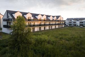 a row of apartment buildings in a field of grass at Apartamenty Lambert Grzybowo in Grzybowo