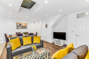 ein Wohnzimmer mit einem Sofa und einem TV in der Unterkunft Mews In Marylebone - Prime Central London in London