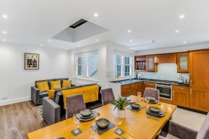 eine Küche und ein Wohnzimmer mit einem Tisch und Stühlen in der Unterkunft Mews In Marylebone - Prime Central London in London