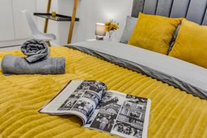 uma cama com um cobertor amarelo e um livro sobre ele em Mews In Marylebone - Prime Central London em Londres