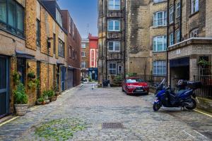 a motorcycle parked on a street in an alley at Mews In Marylebone - Prime Central London in London