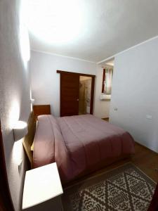 1 dormitorio con 1 cama, 1 mesa y 1 lámpara en Villa Quattro Archi, en Marongiu