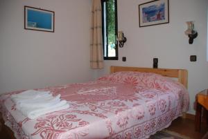 a bedroom with a bed with a red and white blanket at Villas Michalis in Chorafakia