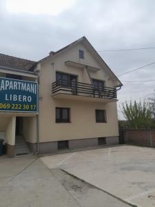 a house with a sign in front of it at LIBERO APARTMANI in Surčin