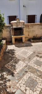 un patio de piedra con horno en un edificio en Casa Orosei Mannu, en Orosei
