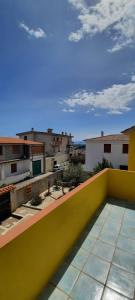 a yellow balcony with a view of buildings at Casa Orosei Mannu in Orosei