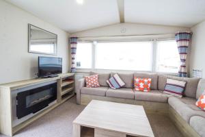 a living room with a couch and a tv at Lovely 6 Berth Caravan For Hire In Norfolk, By A Beautiful Beach! Ref 50030j in Great Yarmouth