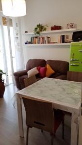 uma sala de estar com uma mesa e um sofá em Savonamare em Savona