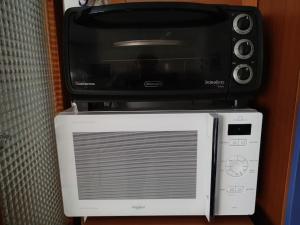 un forno a microonde seduto sopra un tostapane di Alghero, ottimo appartamento a 100 m. dal mare ad Alghero