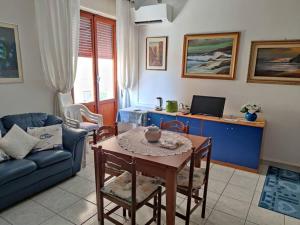 un soggiorno con un tavolo e un divano di Alghero, ottimo appartamento a 100 m. dal mare ad Alghero
