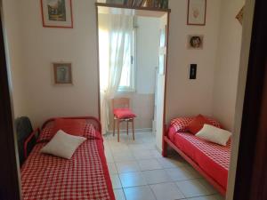 2 posti letto in una camera con lenzuola rosse e finestra di Alghero, ottimo appartamento a 100 m. dal mare ad Alghero