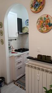 uma cozinha com armários brancos e um forno com placa de fogão em Savonamare em Savona