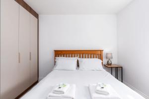 1 dormitorio con 1 cama blanca y 2 toallas blancas en Beautiful Big Family Home - Sleeps 10, Park 3 Cars en Meanwood
