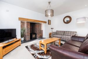 a living room with a couch and a tv and a fireplace at Beautiful Big Family Home - Sleeps 10, Park 3 Cars in Meanwood