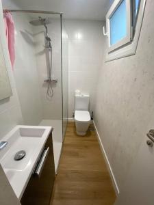 a bathroom with a toilet and a sink and a window at Céntrico piso en Portonovo in Portonovo