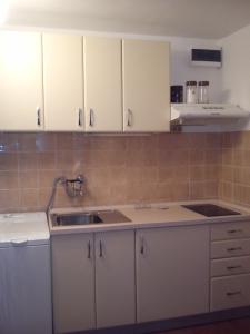 a kitchen with white cabinets and a sink at Apartment Gabre Trogir in Trogir