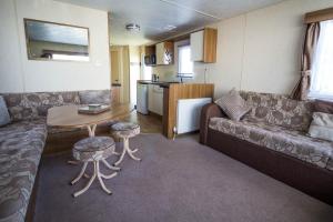 sala de estar con sofá y mesa en 8 Berth Spacious Caravan By The Beach In Norfolk Ref 50059g en Great Yarmouth