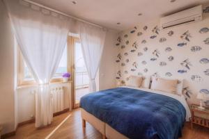 a bedroom with a blue bed and a window at La Casa Sul Mare in Civitavecchia